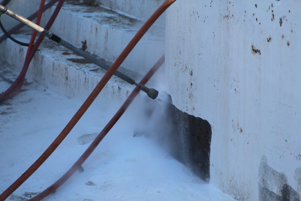 A HP hand lance removing the coating of a pool.
