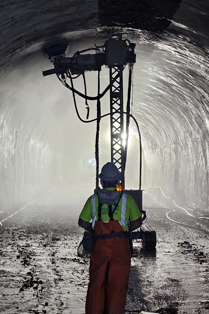 a man operating a hydrodemolition robot in a tunnel