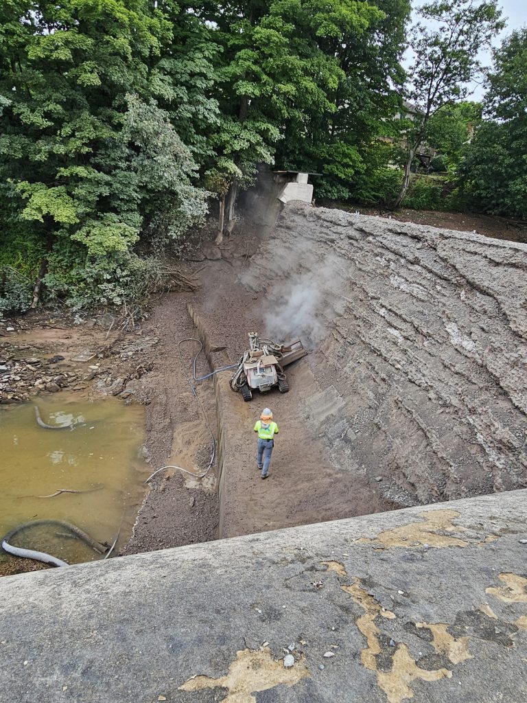 An operator controlling the robot as it performs hydrodemolition.