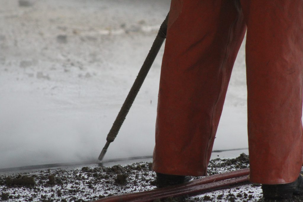 an operator using a hand lance to remove joint sealant.
