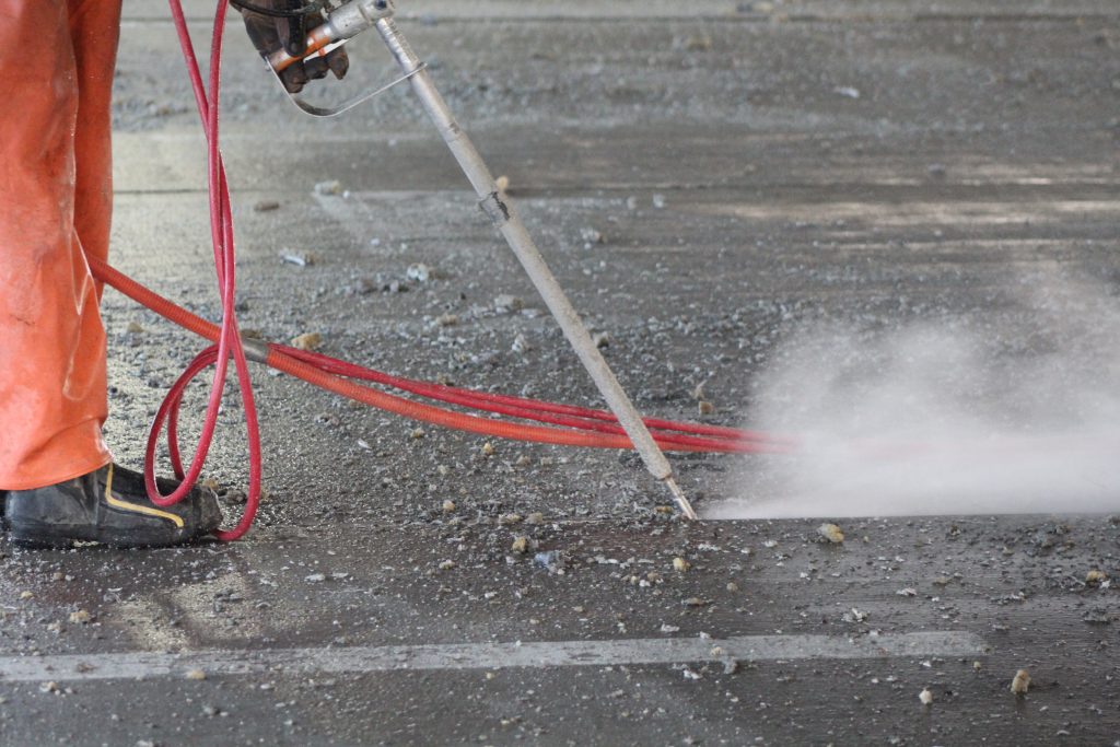 an operator using a hand lance to remove joint sealant.